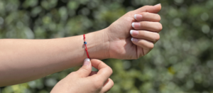 Mano femenina modelando un brazalete Kabbalah.